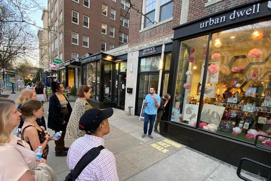 A group gathers outside the Urban Dwell shop during a walking tour in the Adams Morgan neighborhood of Washington, DC.